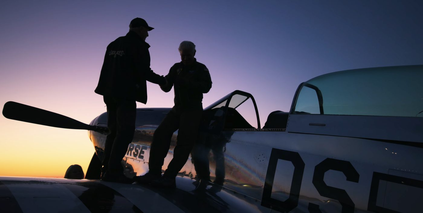 Air show crew with warbird at sunset